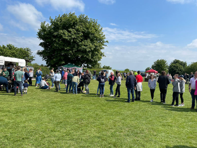 Photo of our kitchen in a field with a long queue of eager customers